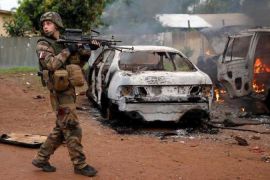 French troops patrol past two Seleka vehicles set on fire by Christian mobs in Bangui, Central African Republic, Monday Dec. 9, 2013. Both Christian and Muslim mobs went on lynching sprees as French Forces deployed in the capital. At least one Seleka suspect was stoned to death by the crowds. (AP Photo/Jerome Delay)