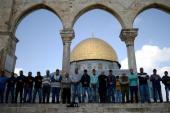 Palestinians pray in front of Dome of the Rock in the Al-Aqsa Mosque compound [Getty Images]