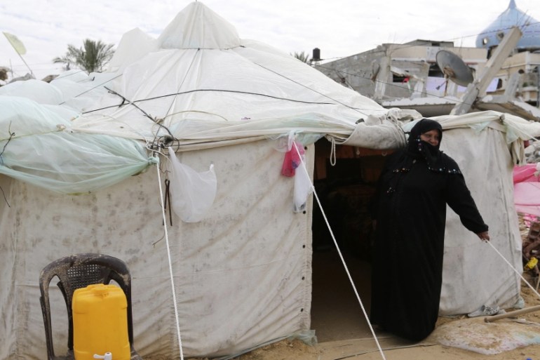 Palestinian woman, whose house was destroyed by what witnesses said was Israel shelling during 50-day conflict last summer, stands outside tent east of Khan Younis in Gaza