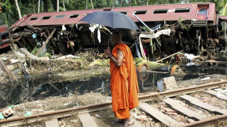 File photo of a Buddhist monk looking at a wrecked train carriage in the town of Paraliya, Sri Lanka