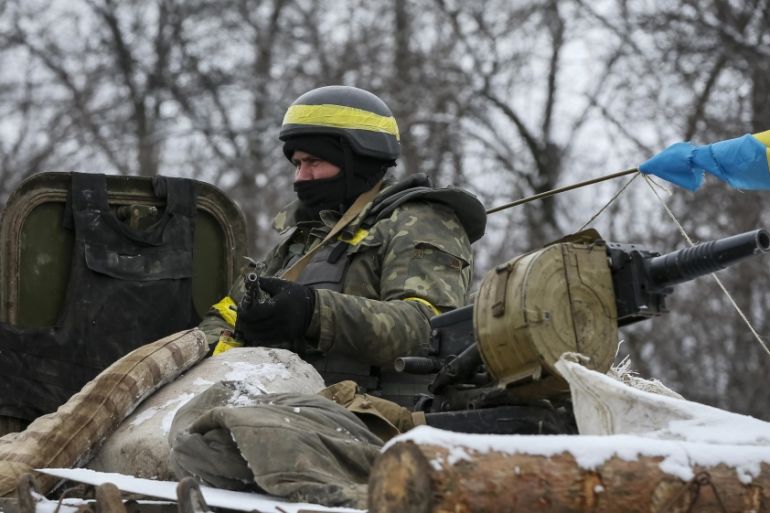 A member of the Ukrainian armed forces rides on an armoured personnel carrier (APC) near Debaltseve