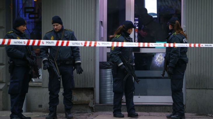 Police officers control the street in front of an internet cafe in Copenhagen