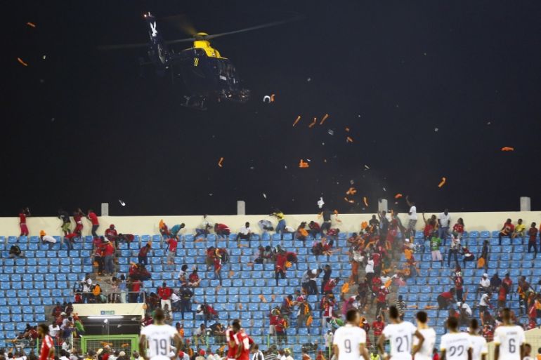 A police helicopter hovers over Equitorial Guinea fans as they throw objects during the 2015 African Cup of Nations semi-final soccer match against Ghana in Malabo