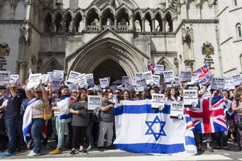 People hold placards and Israeli and Union flags