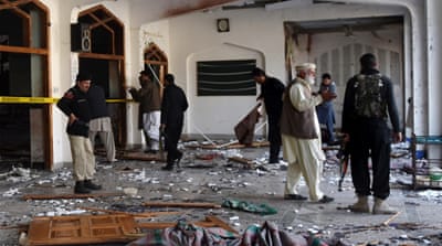 Pakistani security personnel inspect a Shia Muslim mosque after an attack in Peshawar on Friday [AFP]