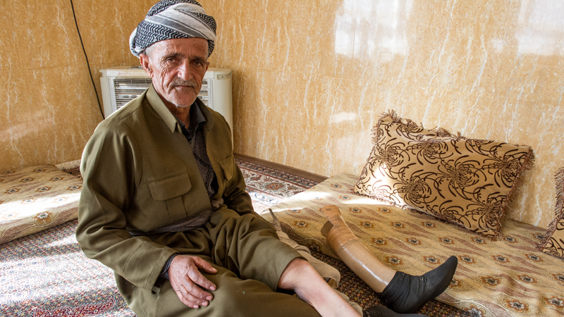 Ghazi Ahmad Ahmad, a resident of Bewasi Saro village in northeastern Iraq, shows his prosthetic limb [Martin Bader/Al Jazeera]