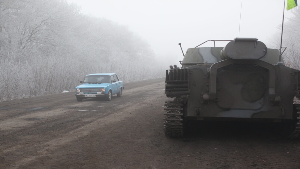 A civilian car drives out of town as the shelling continues [John Wendle] 
