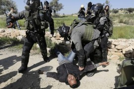 Israeli border policeman detain a Palestinian protester during clashes at a weekly demonstration against Jewish settlements in the West Bank village of Bilin, near Ramallah