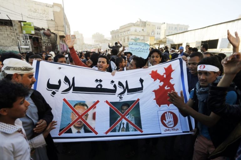 Protesters hold a banner showing crossed-out pictures of U.N. special envoy to Yemen Benomar and leader of Yemen''s Houthis al-Houthi, during a demonstration in Sanaa