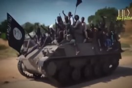 Boko Haram fighters riding a tank in a propaganda video