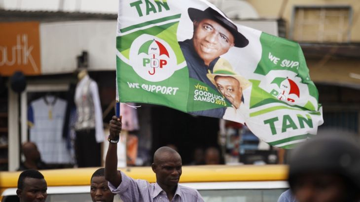 A man holds a flag in support of Nigerian President Jonathan at a campaign rally for Lagos governorship candidate Agbaje in Ikeja