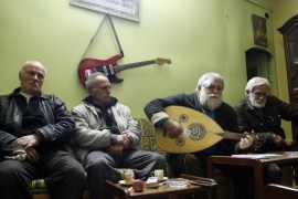 Ibrahim Dawoud plays music on an Oud next to his brother and neighbors inside their home in the ancient Christian quarter of Bab-Touma in Damascus