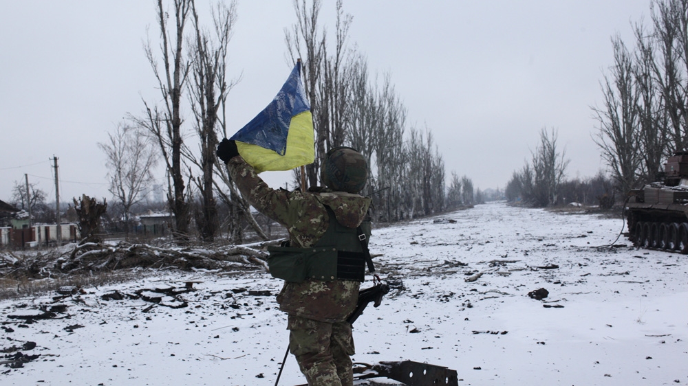 A member of the Sich Battalion risks his life to raise the Ukrainian flag [John Wendle]