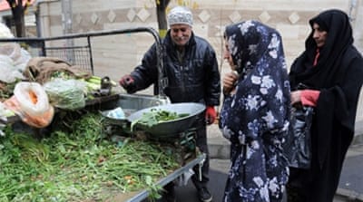 Iranian women buy vegetables from a street vendor in Tehran [Getty]