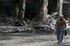 A man on crutches walks in a damaged area from what activists said was due to shelling from forces loyal to Syria''s President Bashar al-Assad in Idlib city, after rebels took control of the area