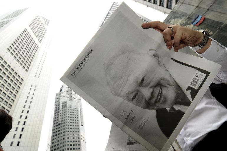 A man reads a newspaper bearing the image of Singapore''s former prime minister Lee Kuan Yew, at Raffles Place in Singapore [REUTERS]