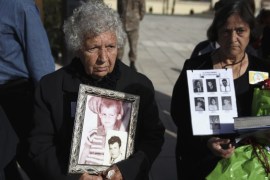 Greek Cypriot women hold photos of relatives missing since 1974 at Tymvos Macedonitissas military cemetery in Nicosia, during a visit by Greek PM Tsipras
