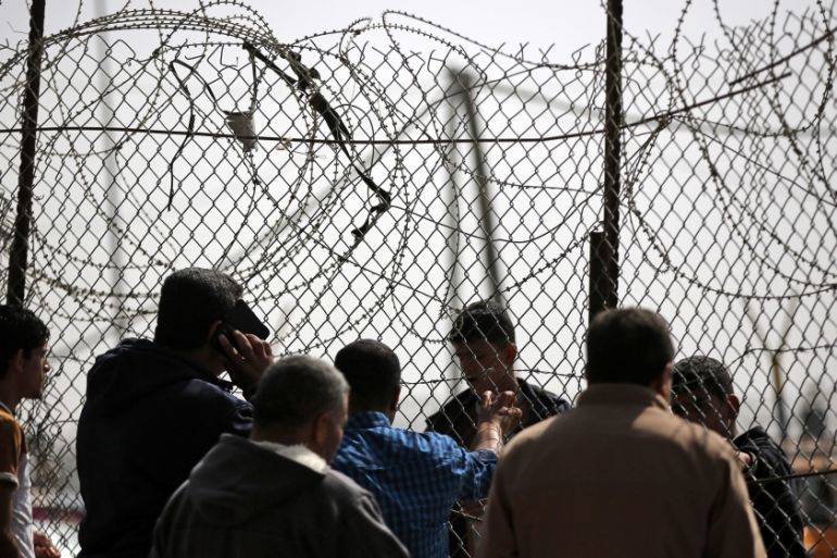 Palestinians wait to cross the border between the Gaza Strip and Egypt