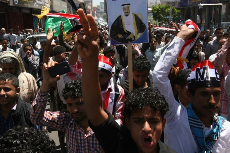 Yemenis hold a poster of the King of Saudi Arabia Salman as they chant slogans during a rally to show support for Saudi-led airstrikes against Houthis [AP]