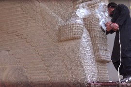 An ISIL militant uses a power tool to destroy a winged-bull Assyrian protective deity at the Ninevah Museum in Mosul, Iraq [AP]