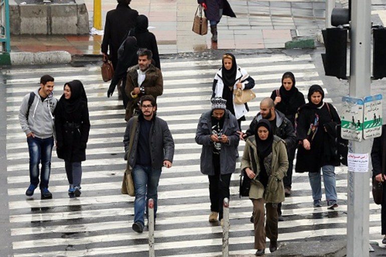 Iranians walk on a street in the capital Tehran [Getty]