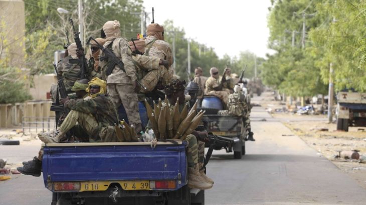 Chadian soldiers hold weapons in the recently retaken town of Damasak