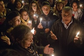 Tunisians holding candles pray at the entrance gate of the National Bardo Museum where scores of people were killed after gunmen staged an attack, Tunis [AP]