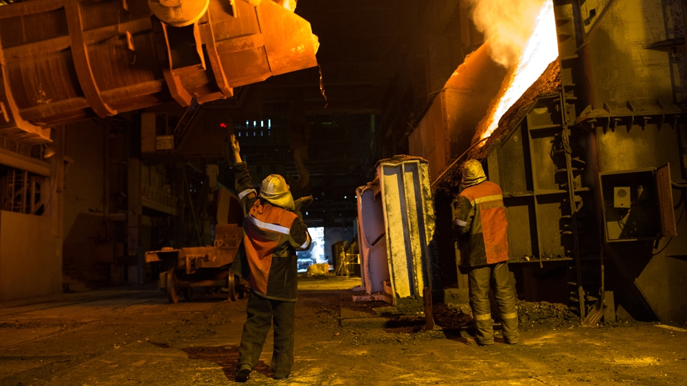 
Steelworkers manoeuvre scrap into a melting oven [John Wendle/Al Jazeera]
