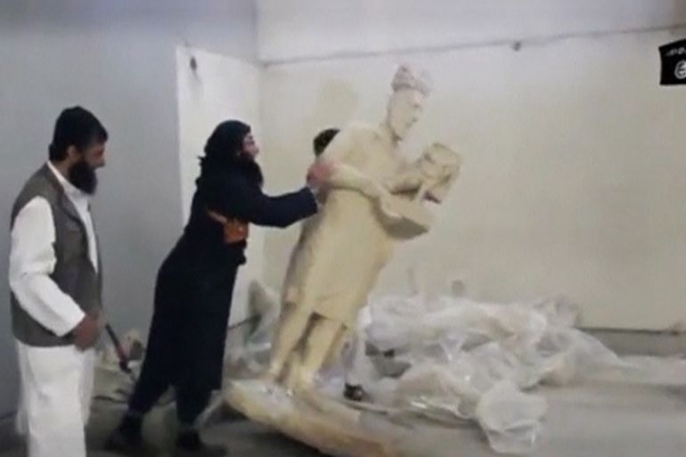A man topples a statue in a museum at a location said to be Mosul