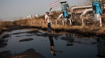 Oil permeates the ground around the abandoned plant [Al Jazeera]