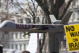 Protesters carry placards near a fake drone in front of the White House during an anti-war march in Washington, DC [AFP]
