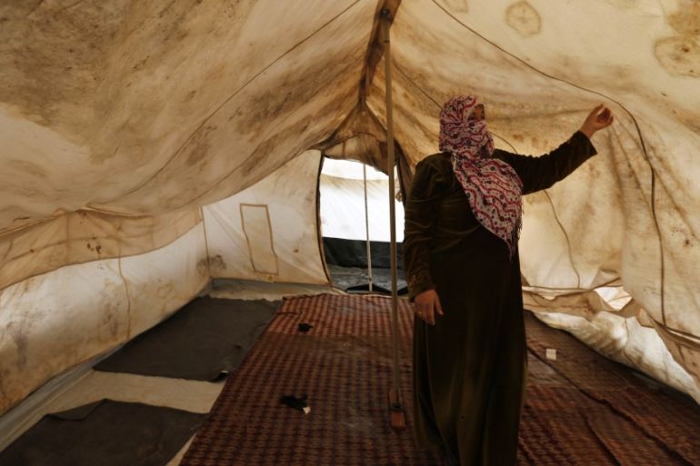 A Syrian refugee stands inside her tent which was affected by a heavy snowstorm at Al Zaatari refugee camp in the Jordanian city of Mafraq, near the border with Syria
