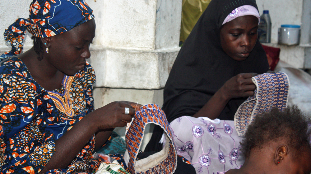 Women whose husbands were killed by Boko Haram sew hats to earn some cash in Maiduguri in northeastern Nigeria [Chika Oduah/Al Jazeera]