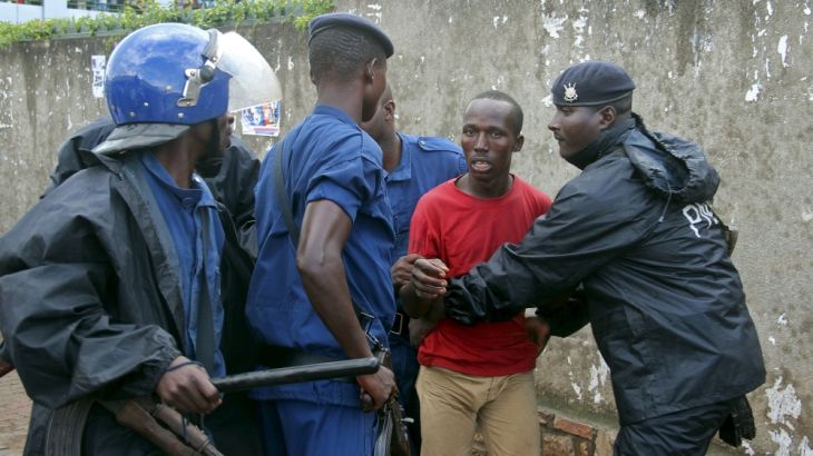 Burundi policemen detain a protestor who opposes President Pierre Nkurunziza from running for a third term, in Bujumbura