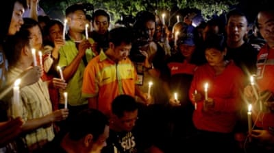 People hold candles to pray for death-row prisoners in Cilacap, Indonesia [AP]