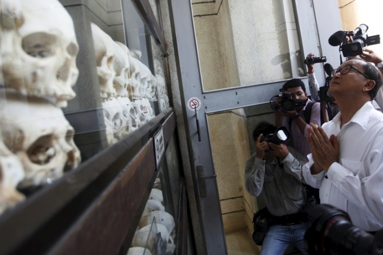 Rainsy (R), President of the CNRP prays in front of the skulls and bones