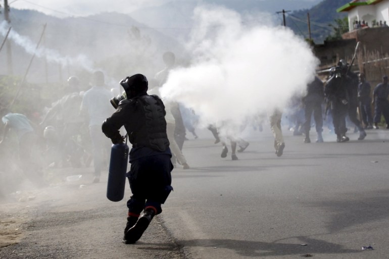 Riot police officer sprays teargas on residents participating in street protests in Burundi''s capital Bujumbura