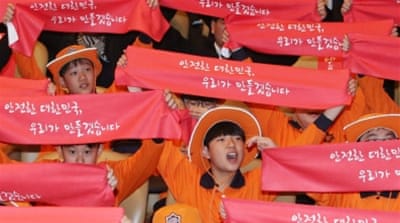 Children unfold red banners reading 'We will make our nation safe' [EPA]