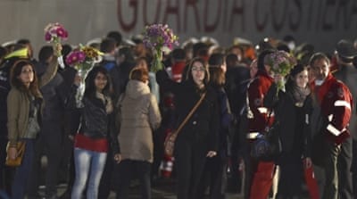 Activists hold flowers as survivors disembark in Italy [AP]