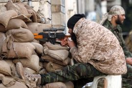 A Libyan soldier monitors a street from his sniper nest in Benghazi [AFP]