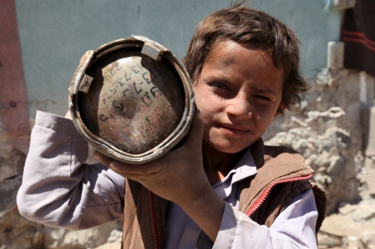 A boy holds a shell which landed which landed from a nearby missile base in Sanaa