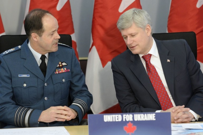 Harper and General Thomas Lawson, Chief of the Defence Staff, talk before making an announcement in Ottawa [AP]