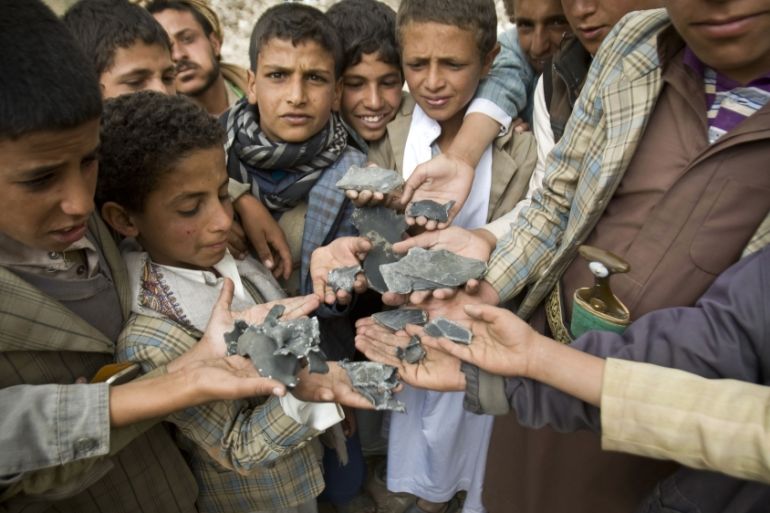 Yemeni boys display shrapnel they collected from the rubble of houses destroyed by airstrikes in a village near Sanaa [AP]