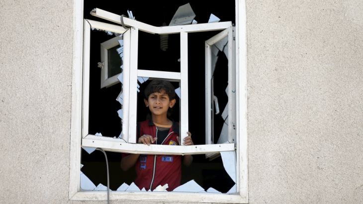 Boy looks through a window of his home damaged by an air strike near Sanaa Airport