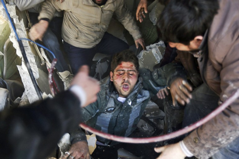 Residents help a man out of rubbles after what activists said was an air strike by forces loyal to Syria''s President Assad in Douma Eastern Al-Ghouta