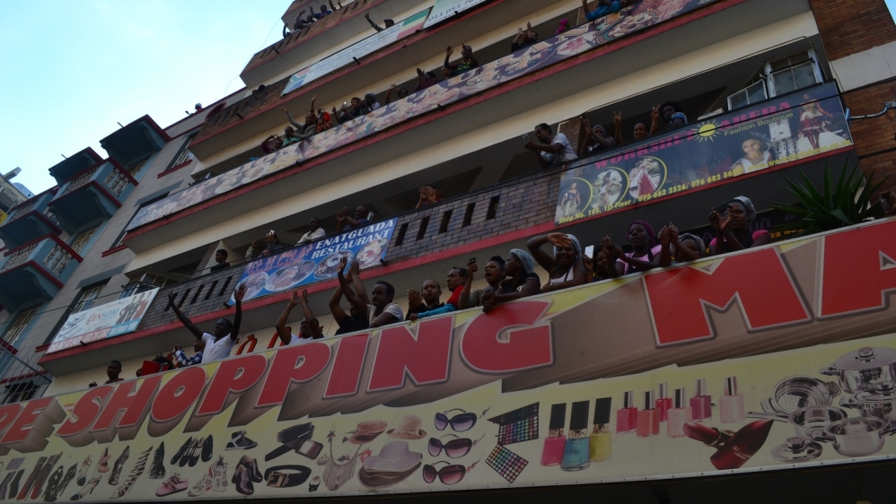 Migrant workers crowded balconies, shouting their support [Khadija Patel/Al Jazeera]