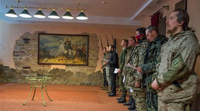 Men from the St Mary's battalion line up in prayers led by Vitaly Chornly, the militia's ideological officer [Abed al-Qaisi/Al Jazeera]