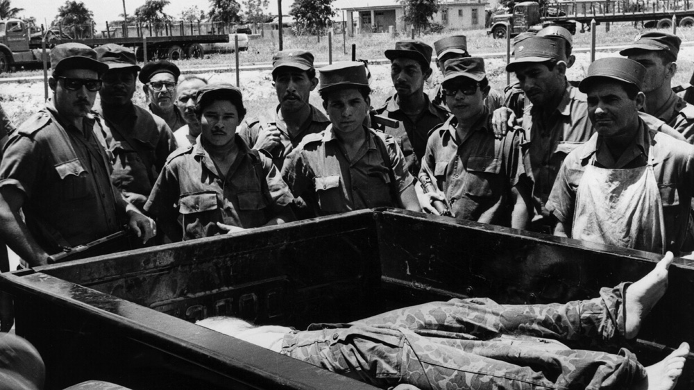 Cuban soldiers stand over the body of a CIA-trained fighter who participated in the ill-fated Bay of Pigs invasion [Getty Images]