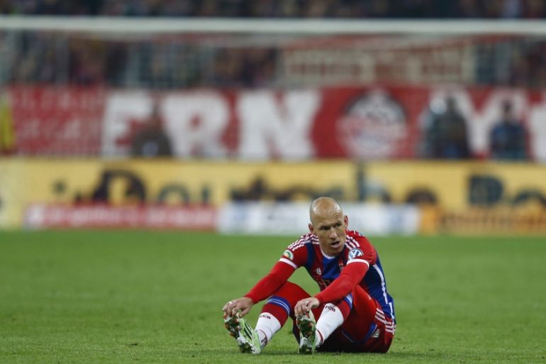 Bayern Munich''s Robben sits on the pitch during German Cup semi-final soccer match against Borussia Dortmund in Munich