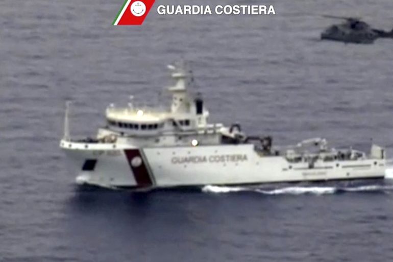 An Italian coast guard vessel and helicopter in migrants search